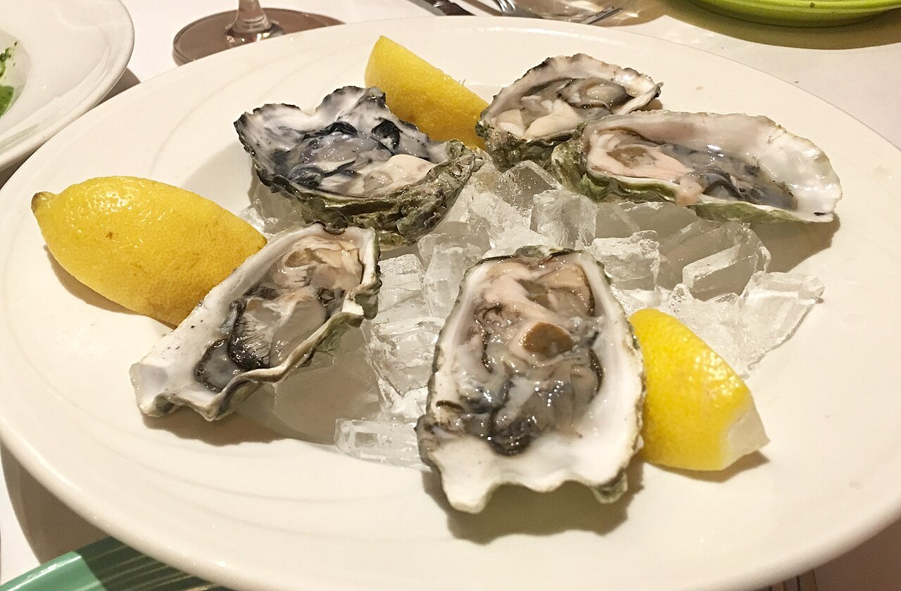 Platter of cold-water oysters on the half shell with lemon wedges