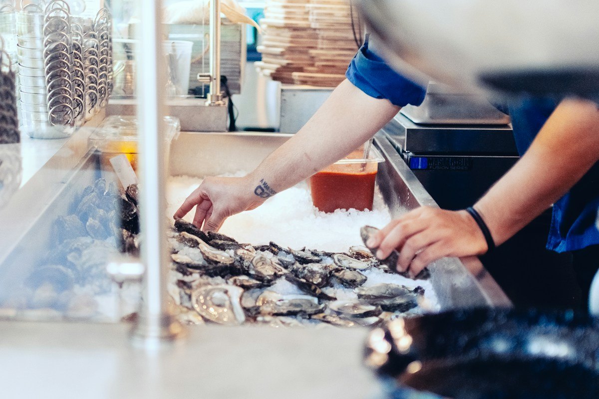 Master shucker preparing live raw bar oysters over crushed ice